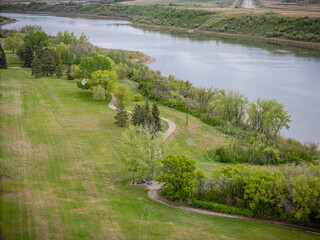 River runs through a grassy field with trees lining the banks