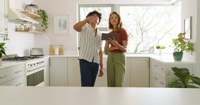 Planning kitchen renovation, diverse couple using digital tablet to discuss design ideas, at home