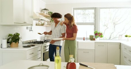 Diverse couple cooking together in modern kitchen, enjoying time and preparing meal, at home - Powered by Adobe