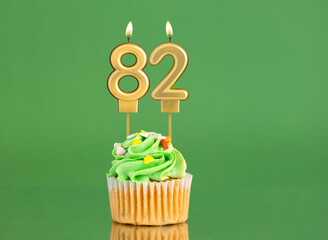 Number 82 birthday candle - Cupcake on a green background