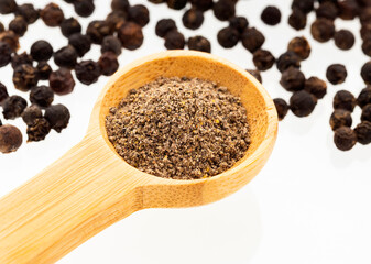 Flavored black pepper powder in a wooden spoon - Piper nigrum