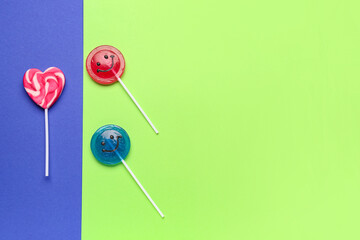 Sweet lollipops on blue and green background