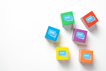Colorful wooden blocks with chat speech bubble icons on white background with copyspace.Concept of communication,social media, messaging,online conversation,discussion forum, and customer feedback.