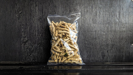 snack in clear plastic packaging on black background - Original basreng snack from lime leaves is a basreng that is not spicy, but remains savory and delicious because of its distinctive spices