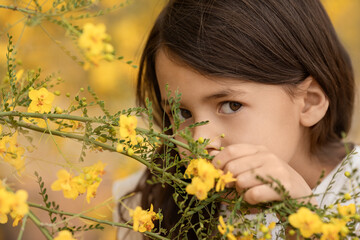 Closeup spring portrait of little girl with yellow flowers at kindergarten age, childhood memories and happy kids concept