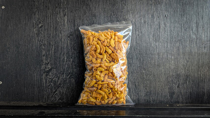 snack in clear plastic packaging on black background - Original macaroni snack (or original...