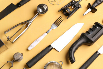 Different kitchen utensils on yellow background