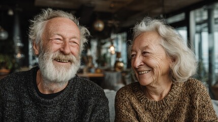 Cheerful elderly man and woman in sunlight-filled modern interior 