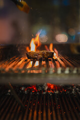 beef steak sizzling on an open flame grill