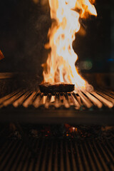 beef steak sizzling on an open flame grill