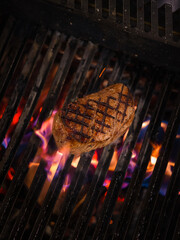 beef steak sizzling on an open flame grill