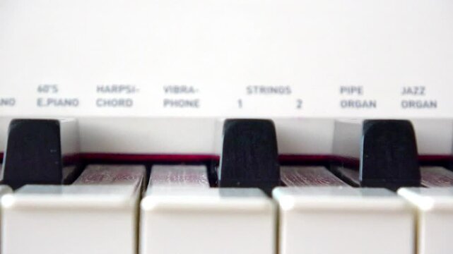 Electronic keyboard piano keys close up view with instrument sound settings panel, white and black keys of digital synthesizer, selective focus. Concept of music education, entertainment industry.