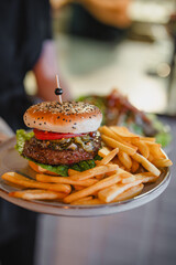 delicious beef burger with fresh vegetables, and sesame bun, served with golden fries, ideal for food and restaurant visuals