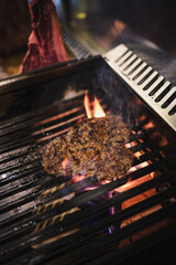 t-bone beef steak sizzling on an open flame grill
