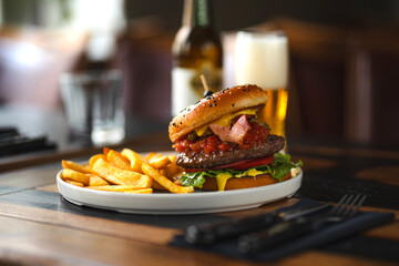 delicious beef burger with fresh vegetables, and sesame bun, served with golden fries and beer, ideal for food and restaurant visuals