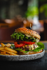 delicious beef burger with fresh vegetables, and sesame bun, served with golden fries, ideal for food and restaurant visuals