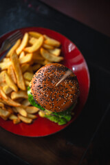 delicious beef burger with fresh vegetables, and sesame bun, served with golden fries, ideal for food and restaurant visuals