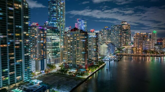 Experience a stunning hyperlapse of vibrant Downtown Miami, highlighting the lively Brickell Key at night, showcasing its impressive skyline and beautiful waterfront that capture the citys essence