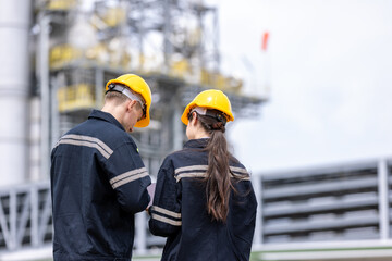 Engineers male, female working with tablet in industry oil refinery oil, gas refinery background,...