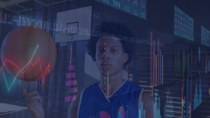 Male athlete spinning basketball on fingertip at gym, as stock charts fading in highlighting trends - Powered by Adobe