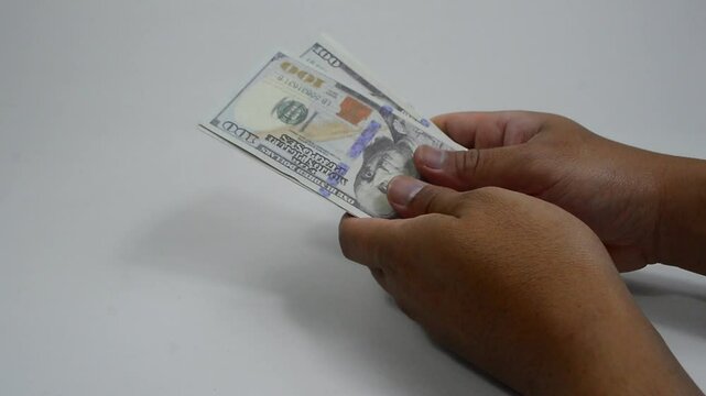 Hands holding a stack of dollar bills with a happy and grateful expression. First paycheck. unexpected fortune
