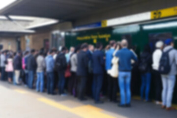 Fototapeta premium the atmosphere at the train station is blurry, people are queuing to get on the train in a crowded place, the background of the station is blurry