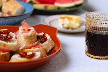 Delicious baguette slices with dried tomatoes, prosciutto, and olive oil, served on a rustic plate