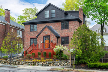Traditional brick homes with lush spring greenery on a quiet street in Brookline, Massachusetts, USA

