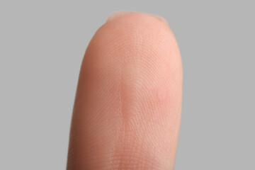 Human fingertip on grey background