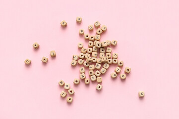 Wooden cubes with English letters on pink background