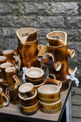 Handcrafted bamboo drinkware and containers on table, featuring range of cups and ashtrays. Collection highlights sustainable design and traditional craftsmanship