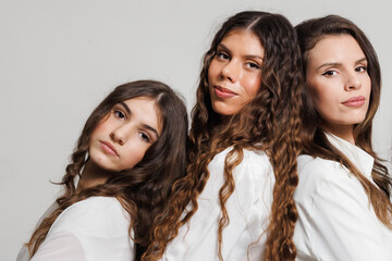 Portrait of three women standing closely together showcasing confidence and unity