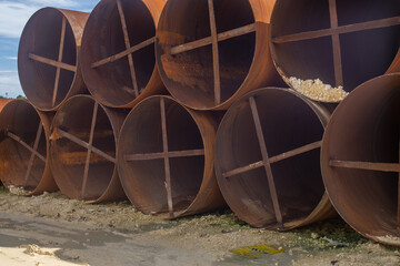 metal casing pipes of large diameter, stacked.  They are used in bridge construction, in...