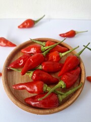 Red chili on a serving board. It is a type of chili that has a strong spicy taste and is often used in cooking and medicine. This chili is known for its slender shape, bright red color, high level of 