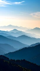Fototapeta premium Layered blue mountains recede into a hazy, distant horizon under a soft, pale sky with light clouds.