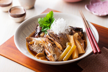 【鯛のあら煮と日本酒】春が旬の鯛。そのアラを出汁で丁寧に炊き上げます。旨みが染み渡ったら、筍とふきをあわせ白髪ねぎを添えて春らしく仕上げます。 © FOODPHOTO