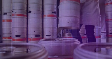 Low-angle shot showing brewery worker approaching kegs and lifting steel keg for storage alignment