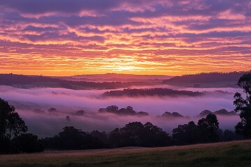 Fototapeta premium Scenic landscape with fog blanketing the hills at beautiful sunrise. It can be used for travel, nature, and spiritual themes.