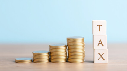 Stack of coins increasing height next to wooden blocks of tax box.