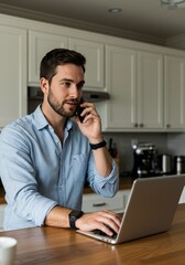 Man Using Laptop Talking on Phone in Bright Kitchen at Home