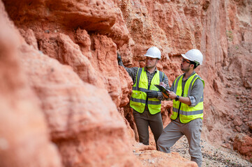 Expert geologists and explorers are working together to examine the rock layers in a mountain to determine the minerals in the rock layers.