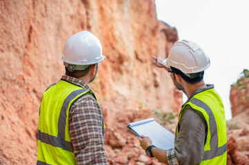 Expert geologists and explorers are working together to analyze rock layers near a cliff in a...