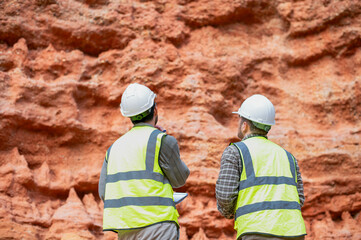 Expert geologists are working together to examine minerals in different layers of rock on a mountain.