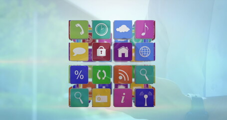 Image of cube with icons over person using smartphone