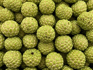 Obraz premium A vibrant, textured background of freshly harvested green custard apples. A concept of natural abundance and wholesome tropical fruit.