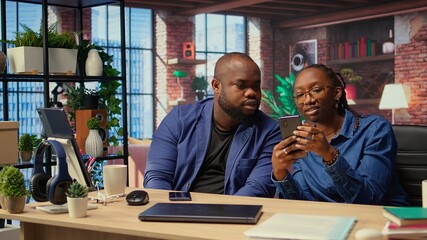 African American couple in their modern home work together on a freelance project, focusing on...