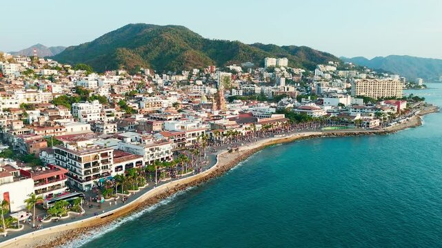 Pride parade passing through downtown puerto vallarta mexico at sunset, church standing out in background