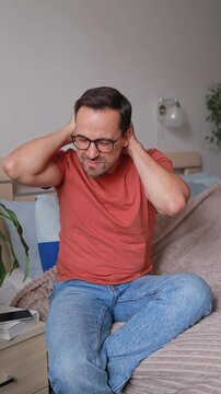 Vertical Video Man Massages Head and Back of Neck Due to Headache