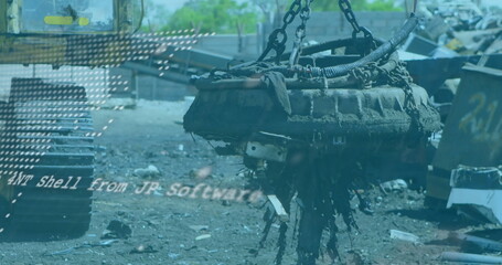 Hoisting electromagnet lifter raising corroded engine block over scrap yard, with heavy chains