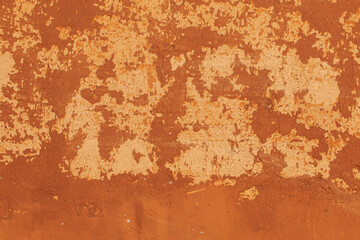 Close-up photo of cracked orange painted cement surface.